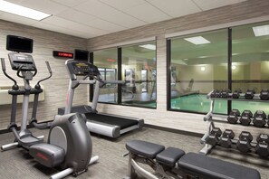 A gym with treadmills, an elliptical, a bench, and a rack of dumbbells. - Courtyard by Marriott Dallas Mesquite (Mesquite)