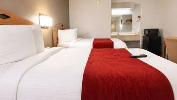 A hotel room with two beds, a desk, a microwave, and a mirror.