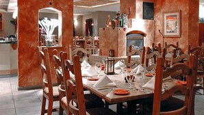 A dining area with a long table set for a meal, surrounded by wooden chairs. - Gold Dust West Carson City (Carson City)