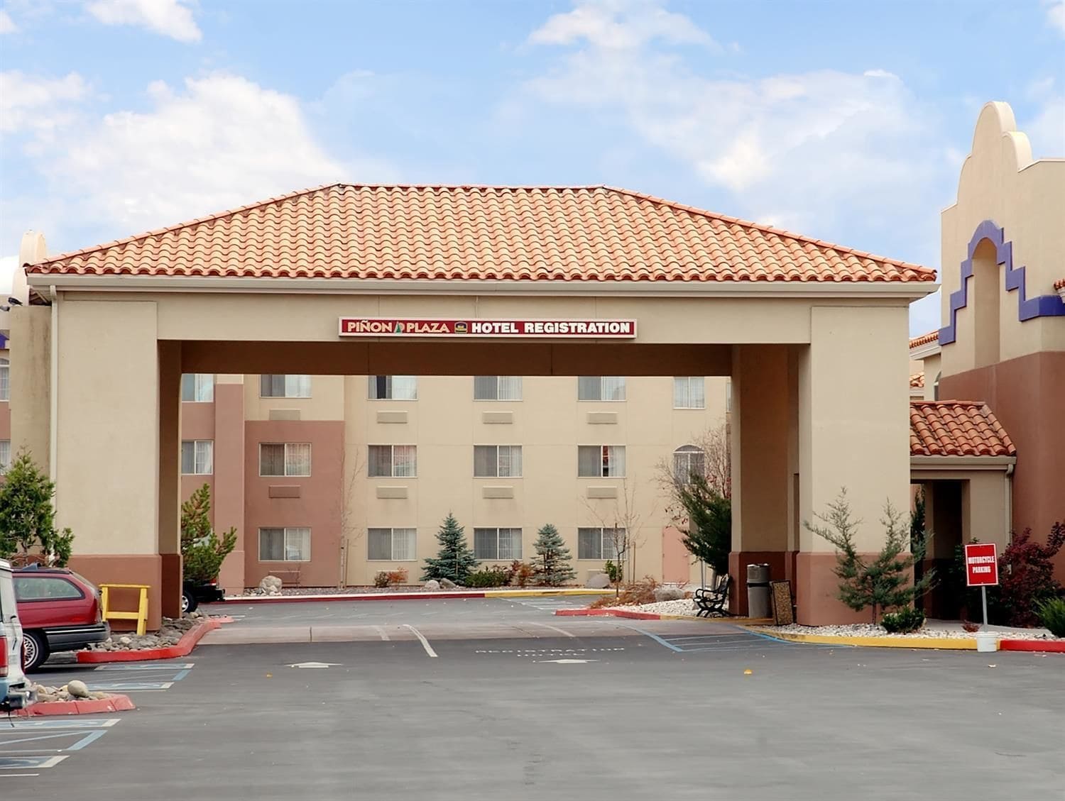 A hotel registration area with a tiled roof and a sign above the entrance.