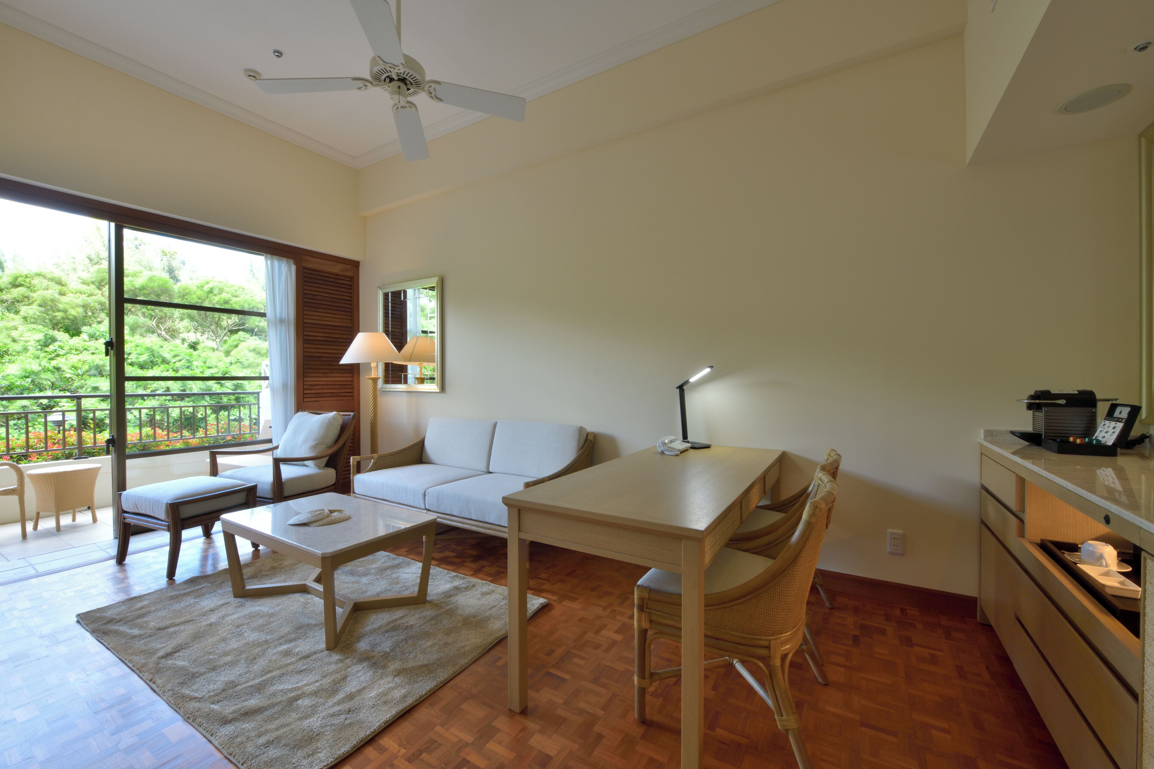 A spacious living area with a sofa, a dining table, and a kitchen area.