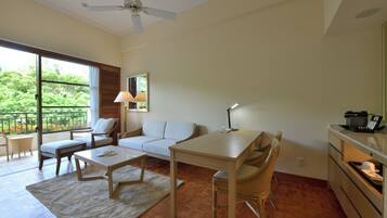 A spacious living area with a sofa, a dining table, and a kitchen area.