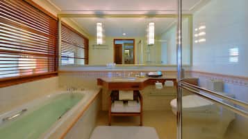 A modern bathroom with a bathtub, a glass-enclosed shower, a vanity with a sink, and a large mirror.