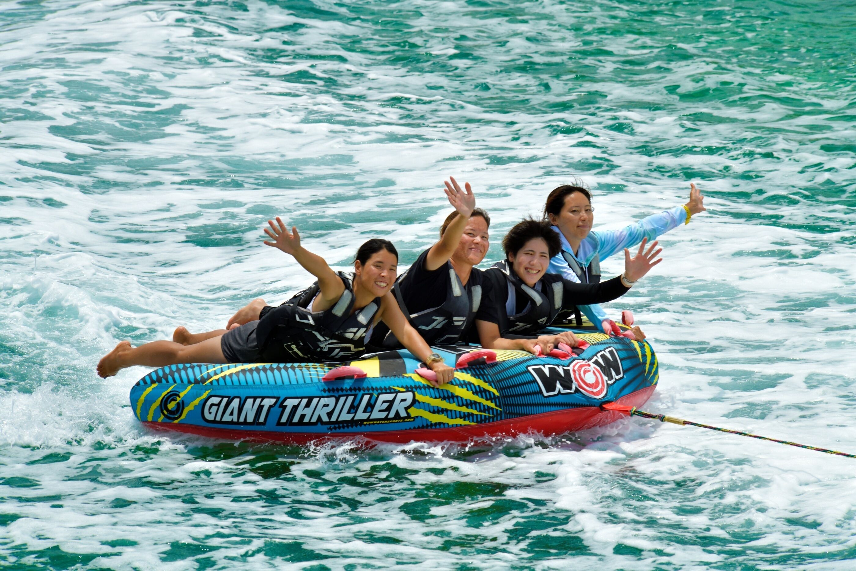 A group of people on a water ride with a colorful inflatable raft.