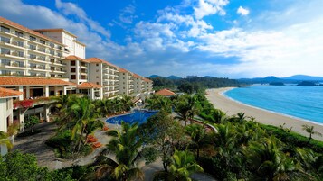 Un resort con piscina, playa y vista al océano.