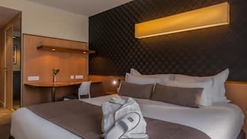 Une chambre d’hôtel avec un grand lit, un bureau et une chaise.