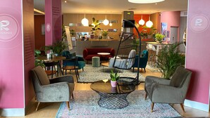 Un espace détente moderne avec des sièges, une table basse et des luminaires suspendus.