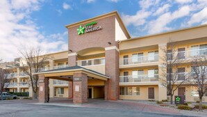 A multi-story hotel with a prominent Extended Stay America sign, a lobby area, and a parking lot.
