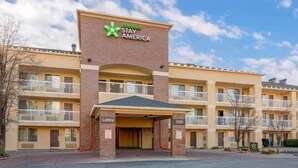 A multi-story hotel with a prominent Extended Stay America sign, a lobby entrance, and a parking area.