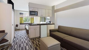 A compact hotel room with a kitchenette, a sofa, and a dining area. - Microtel Inn & Suites by Wyndham Richmond Airport (Sandston)