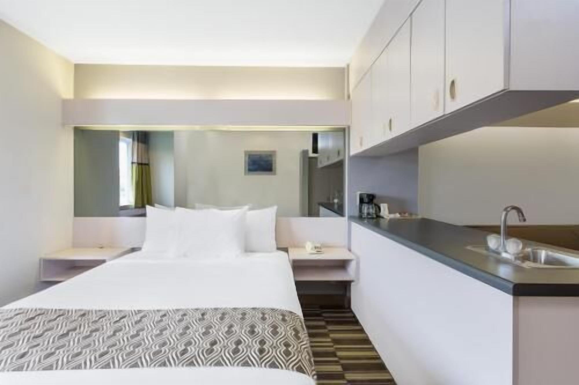 Escritorio, cortinas opacas, tabla de planchar con plancha