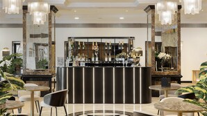 A bar area with a marble countertop, multiple hanging light fixtures, and a variety of bottles. - Dom Pedro Lisboa Hotel, a member of Radisson Individuals (Lisbon)