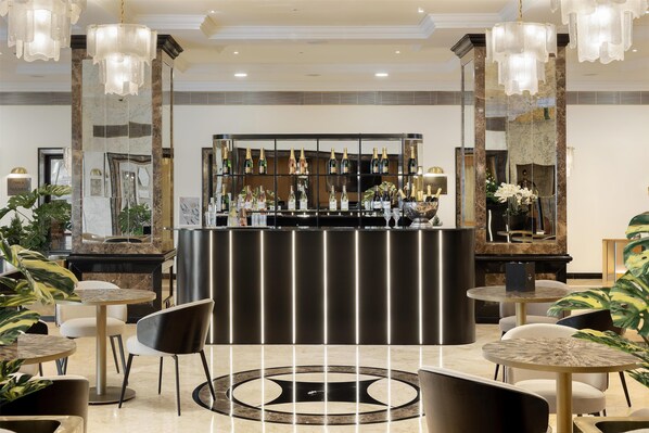 A bar area with a marble countertop, multiple hanging light fixtures, and a variety of bottles. - Dom Pedro Lisboa Hotel, a member of Radisson Individuals (Lisbon)