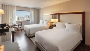 A hotel room with two beds, a desk, a chair, and a large window offering a city view. - Dom Pedro Lisboa Hotel, a member of Radisson Individuals (Lisbon)