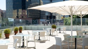A rooftop terrace with outdoor seating, potted plants, and a view of modern buildings. - Dom Pedro Lisboa Hotel, a member of Radisson Individuals (Lisbon)