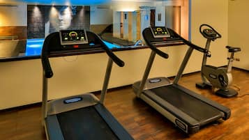 Un gimnasio con dos cintas de correr y una máquina elíptica.