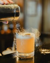 Un cocktail versato in un bicchiere, creando schizzi.