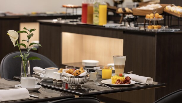A breakfast buffet with various food items, a coffee station, and a juice bar. - Dom Pedro Lisboa Hotel, a member of Radisson Individuals (Lisbon)