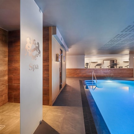 A modern spa area with a pool, wooden walls, and a sign indicating a spa.
