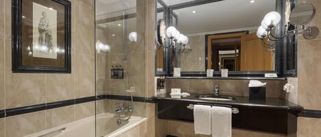 Une salle de bain moderne avec une baignoire, un grand miroir et un meuble-lavabo.