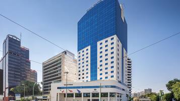 A modern building with a prominent blue glass facade and a sign reading "Dom Pedro."