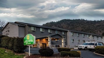 A La Quinta Inn & Suites hotel with a stone facade, multiple windows, and a parking lot.