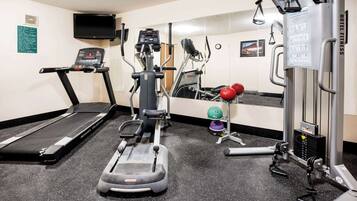 A hotel fitness center with a treadmill, elliptical, and weight machines.