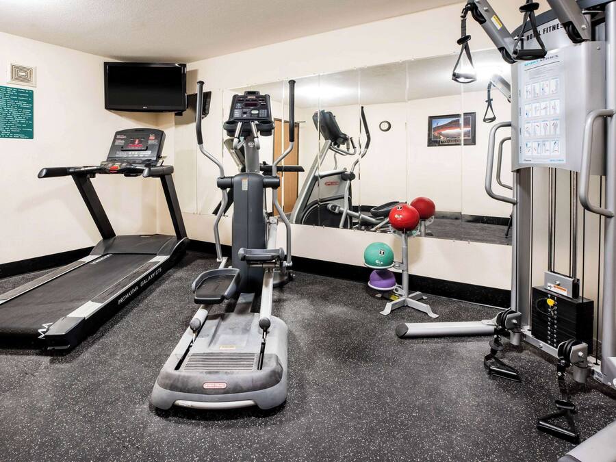 A hotel fitness center with a treadmill, elliptical, and weight machines.