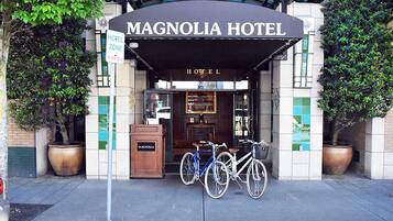 The exterior of the Magnolia Hotel with a sign indicating a hotel zone and a bike parking area.