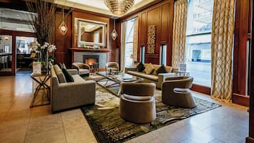 A spacious lobby with a fireplace, comfortable seating, and large windows.