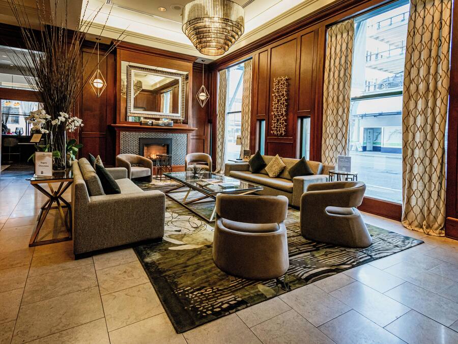 A spacious lobby with a fireplace, comfortable seating, and large windows.