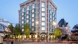 A multi-story hotel with a prominent 'HOTEL' sign, featuring a classic architectural style with a peaked roof and large windows.