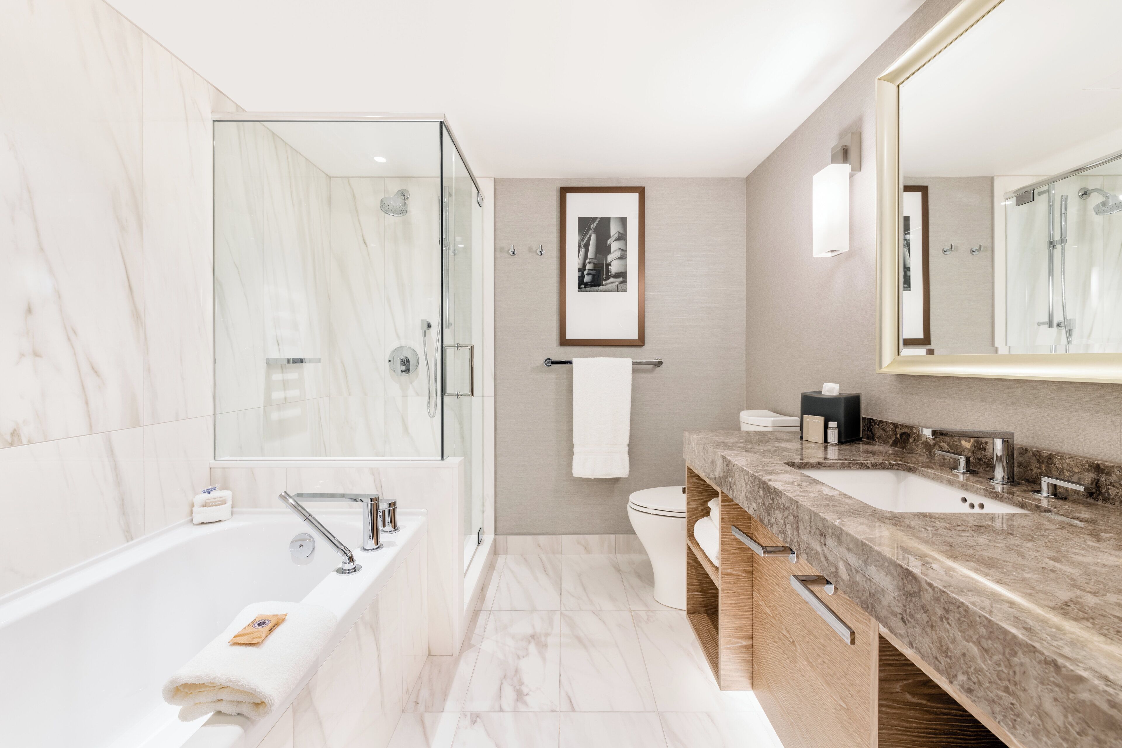 A modern bathroom with a large bathtub, a shower area, and a vanity with two sinks.