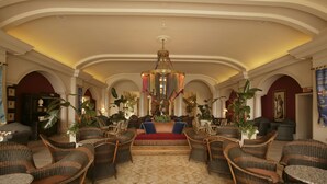 A spacious lobby with a central seating area, high ceilings, and a chandelier. - Universal’s Loews Portofino Bay Hotel (Orlando)