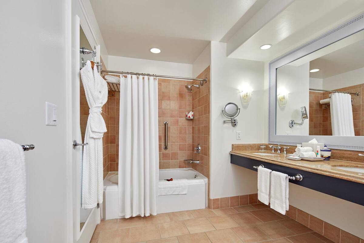 Une salle de bain moderne équipée d’une baignoire, d’une douche et d’un meuble-lavabo.