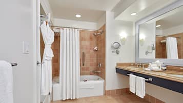 Une salle de bain moderne équipée d’une baignoire, d’une douche et d’un meuble-lavabo.