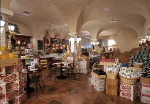A spacious store with high ceilings and arched structures, featuring a variety of products including boxed goods and baskets.