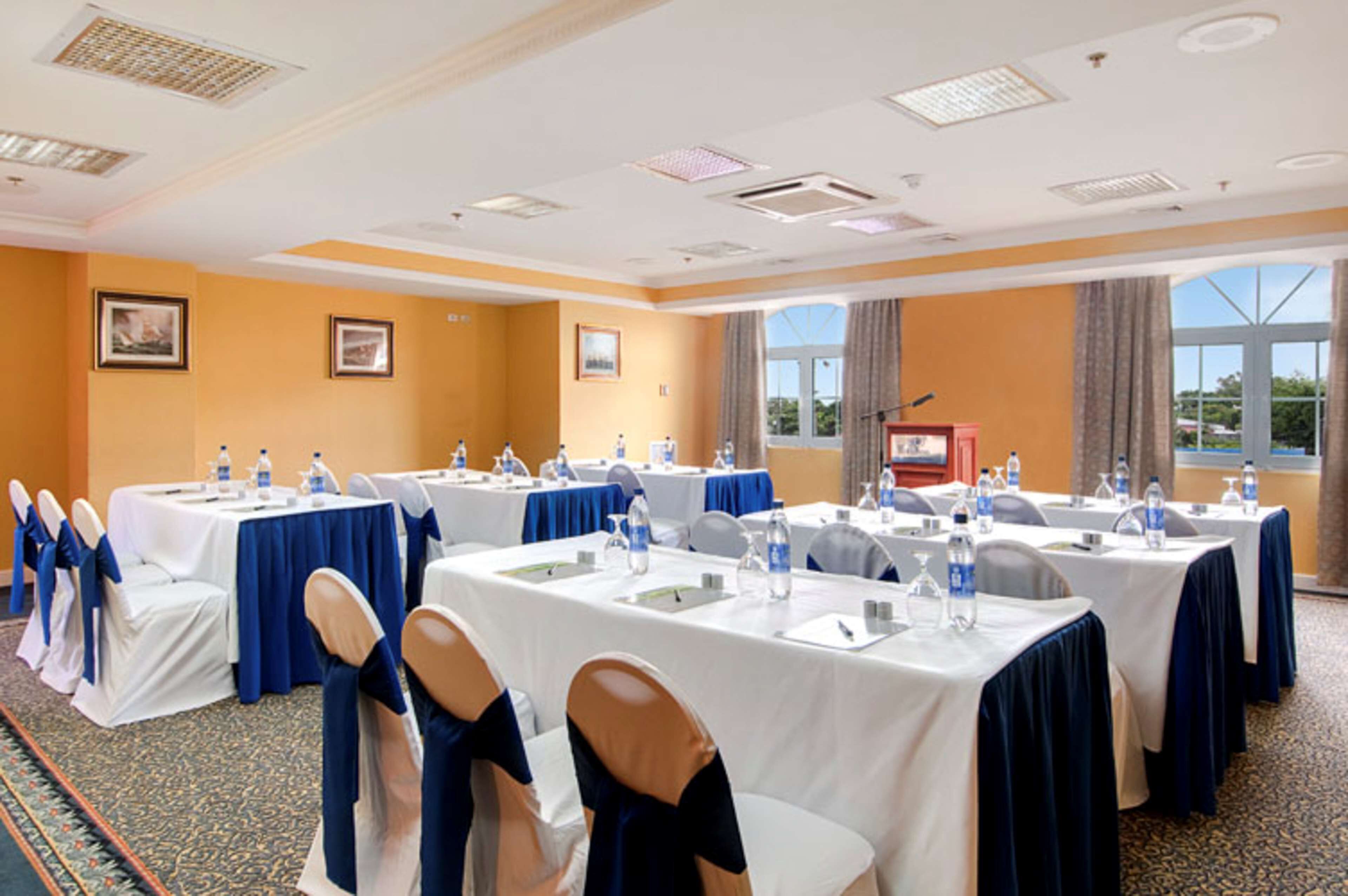 A conference room with multiple tables, chairs, and water bottles.