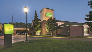 A La Quinta Inn & Suites building at dusk with a well-lit entrance and a parking lot. - La Quinta Inn & Suites by Wyndham Minneapolis Northwest (Brooklyn Park)