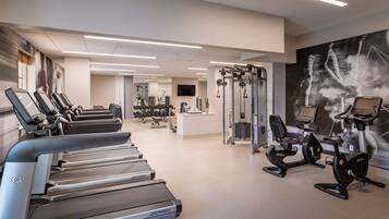 A gym with treadmills, elliptical machines, and weight equipment.
