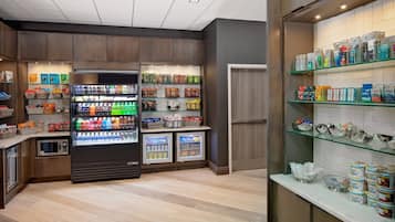 Una estación autoservicio con bebidas frías, aperitivos y una variedad de productos envasados.