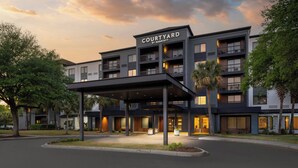 A multi-story hotel with a covered entrance and balconies. - Courtyard by Marriott Myrtle Beach Barefoot Landing (Myrtle Beach)