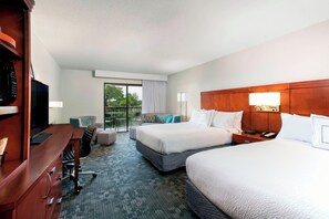 Relax in this stylish room with two single beds, a desk, and a large window offering a view of the outdoors.