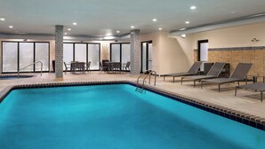 A swimming pool with lounge chairs and a seating area with tables and chairs. - Courtyard by Marriott Myrtle Beach Barefoot Landing (Myrtle Beach)