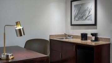 A compact kitchen with a sink, a coffee maker, and a dishwasher.