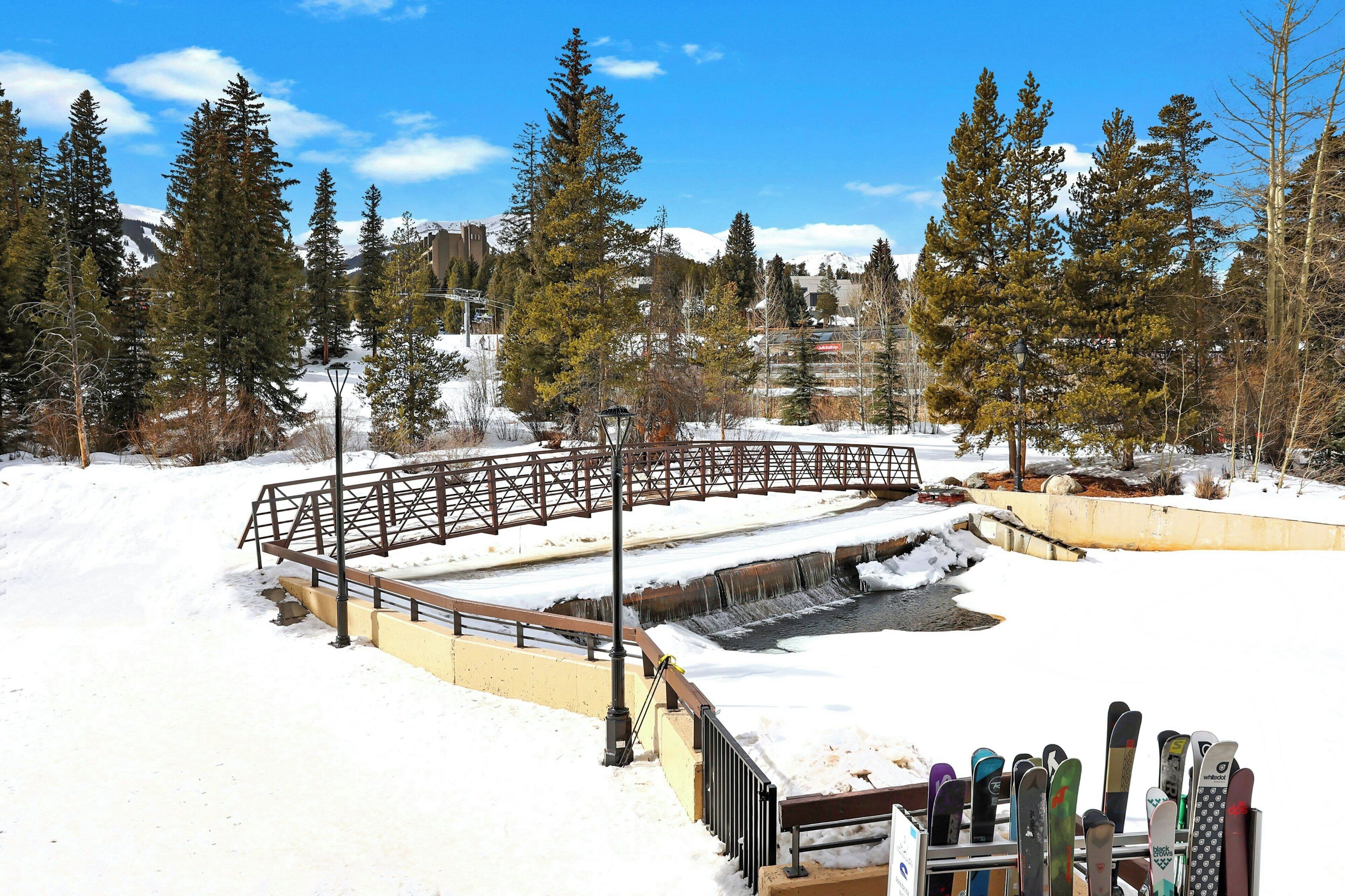A snow-covered outdoor area with a wooden bridge and a ski lift.