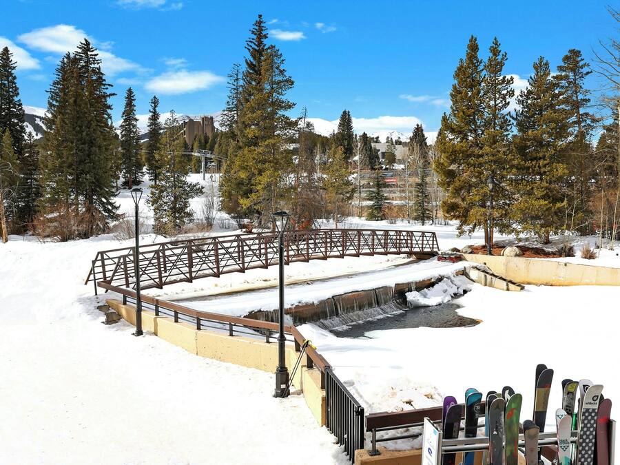A snow-covered outdoor area with a wooden bridge and a ski lift.