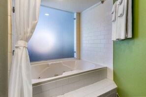 A bathroom with a bathtub, a window, and a towel rack.