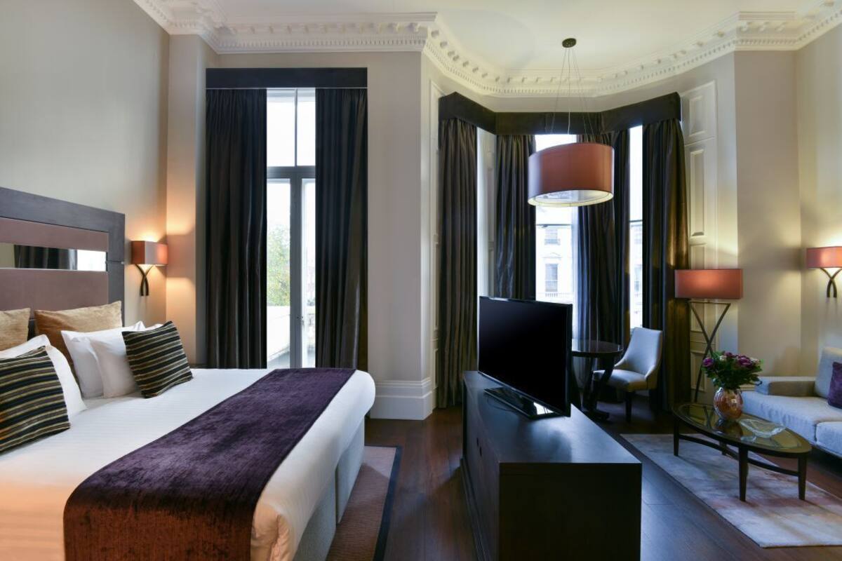 Une chambre d’hôtel dotée d’un grand lit, d’une télévision à écran plat, d’un bureau et d’un canapé.