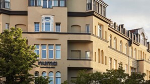 Un edificio de varios pisos con fachada color beige, ventanas grandes y balcones.